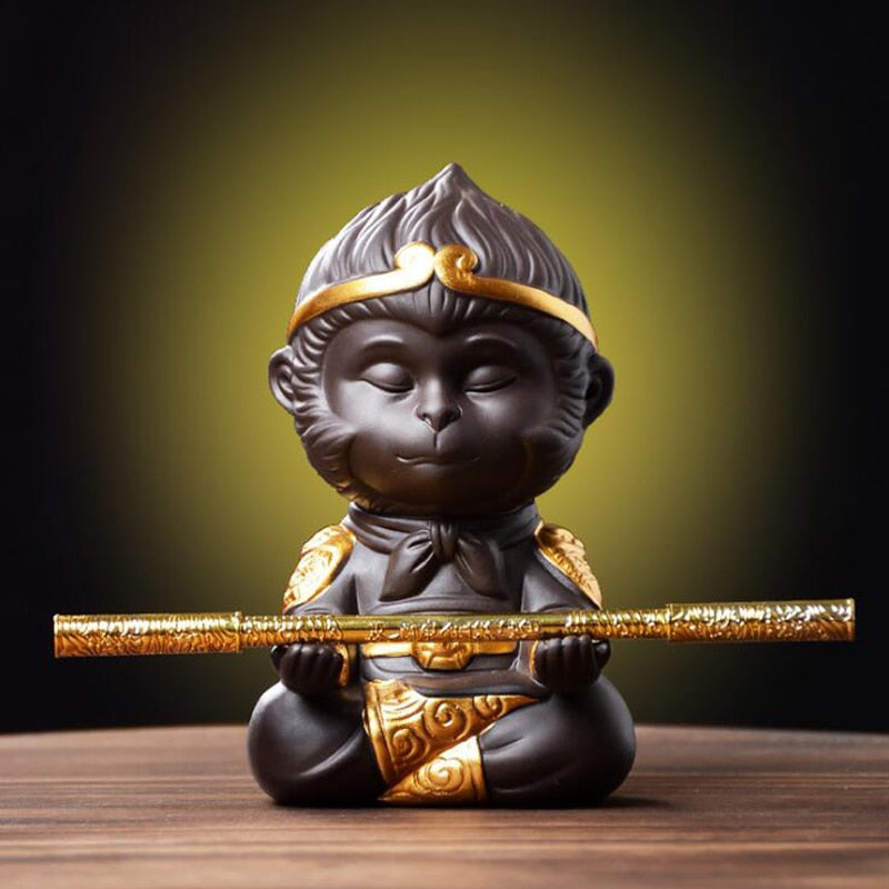 Decorative figurine of a monkey with gold accents on a wooden surface