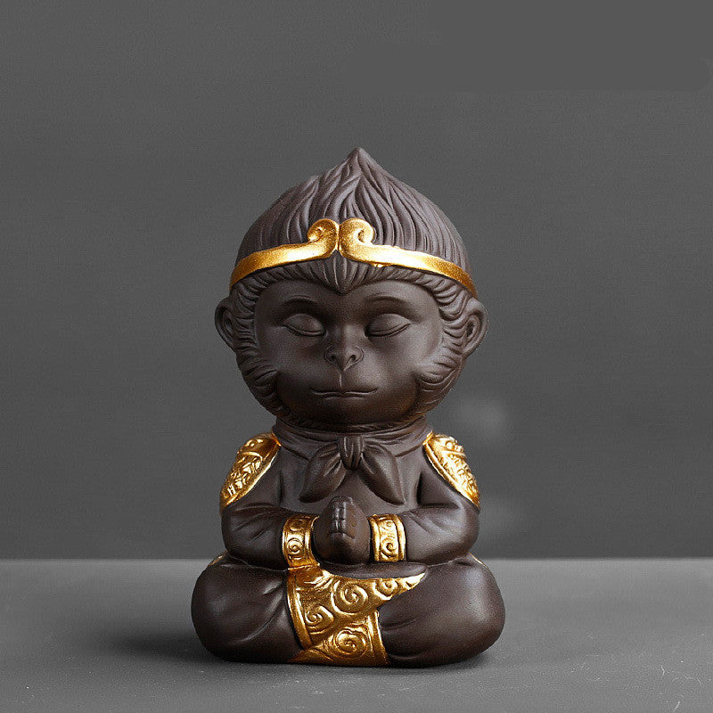 Decorative monkey figurine with gold accents on a gray background