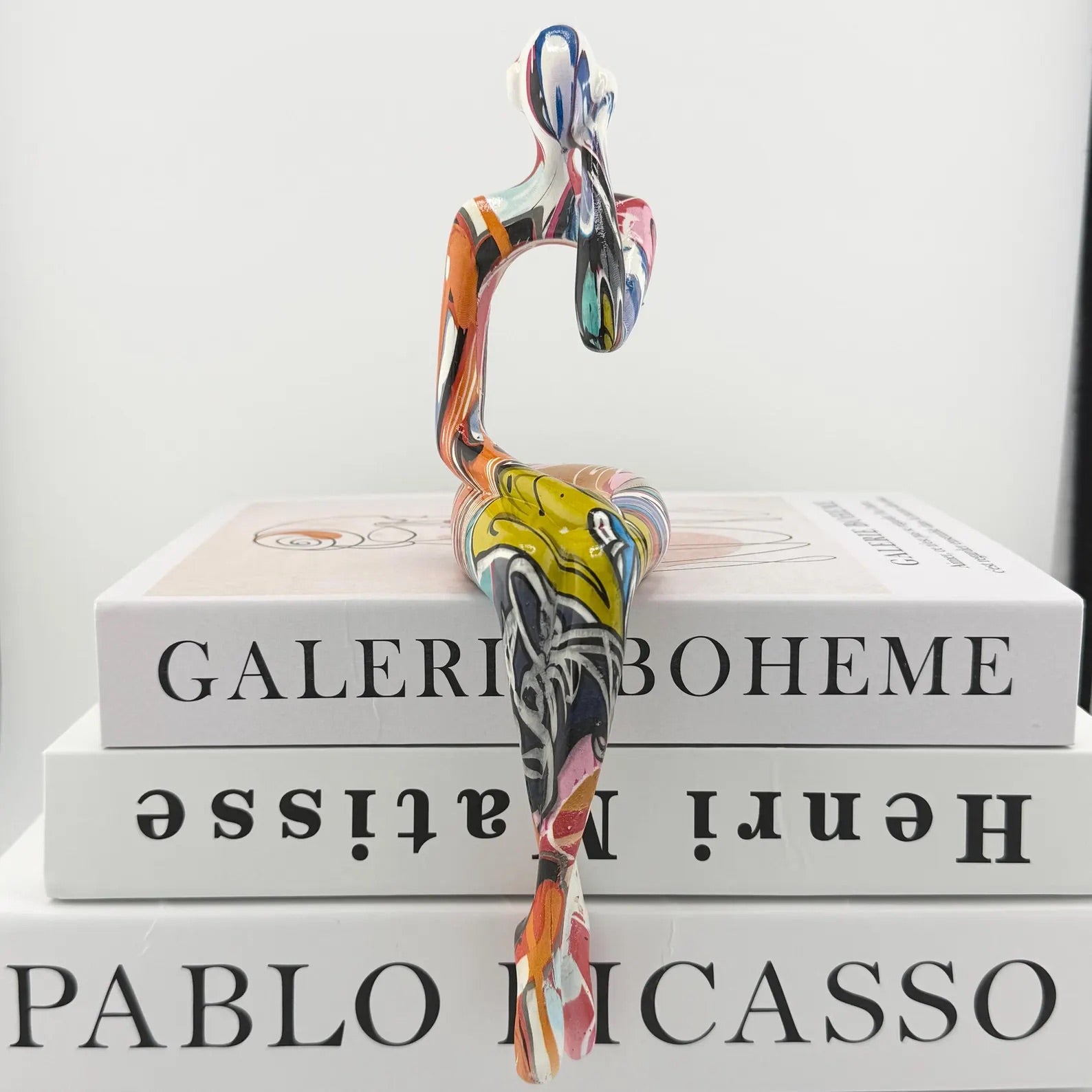 Minimalist colorful resin sculpture of three seated figures for modern home décor
