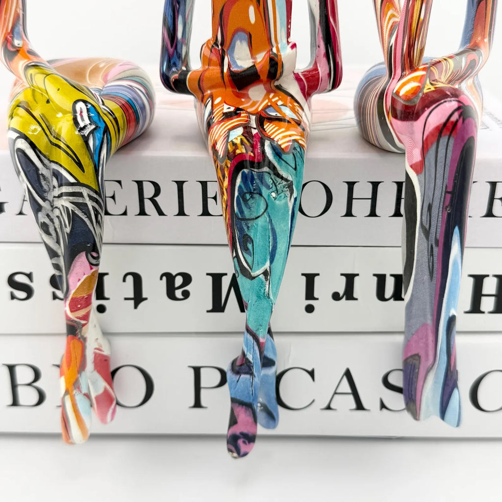 Minimalist colorful resin sculpture of three seated figures for modern home décor
