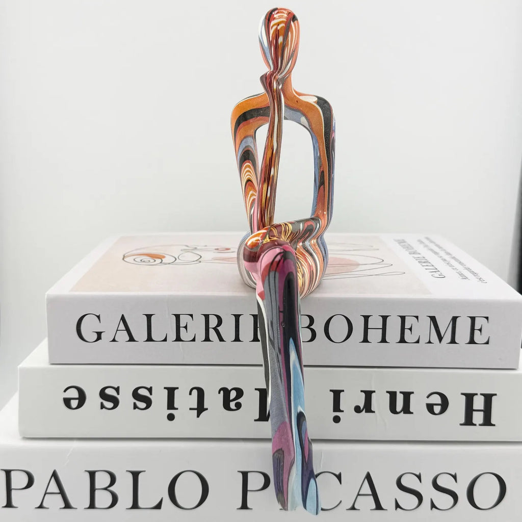 Minimalist colorful resin sculpture of three seated figures for modern home décor
