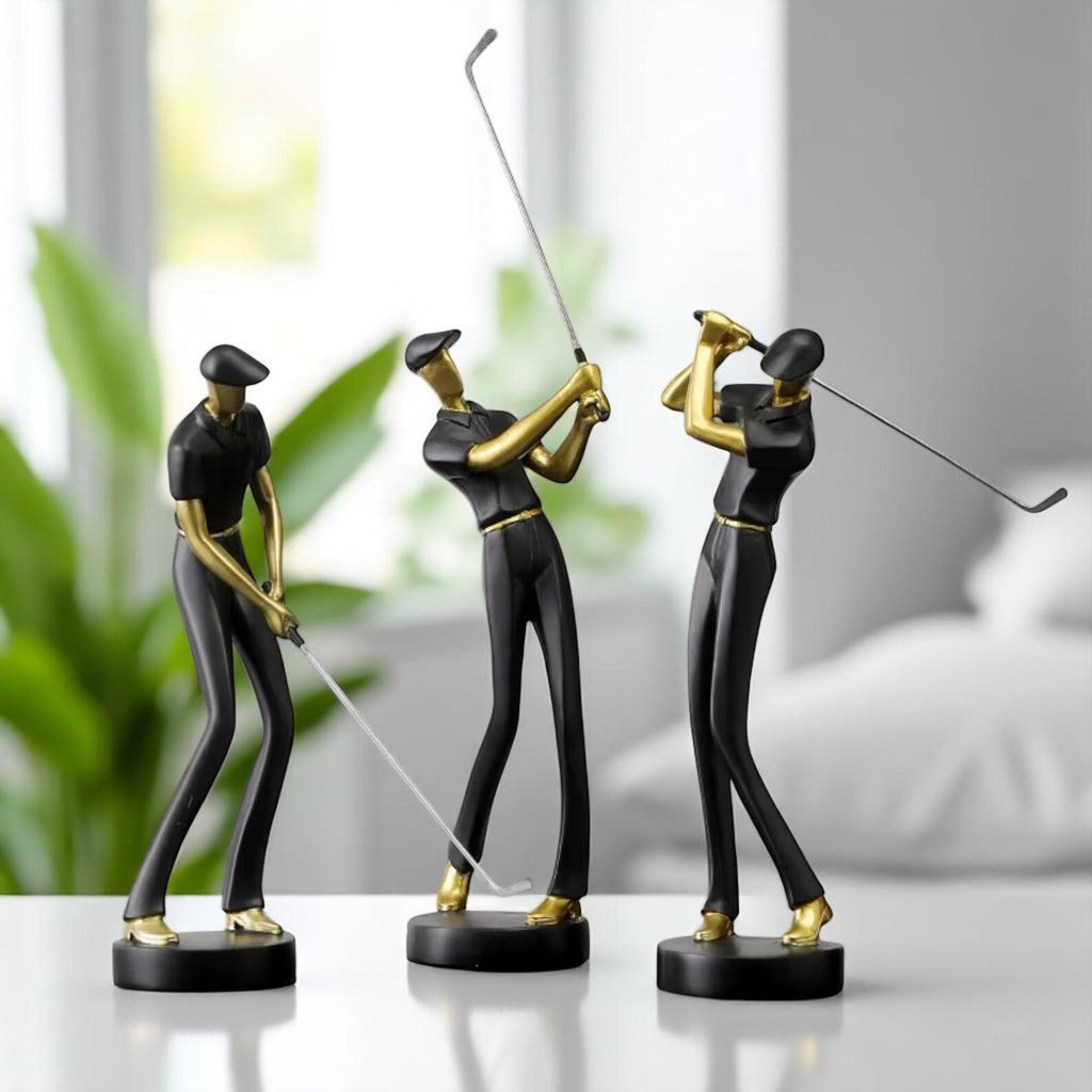 Three golf-themed figurines on a white surface with a blurred indoor background