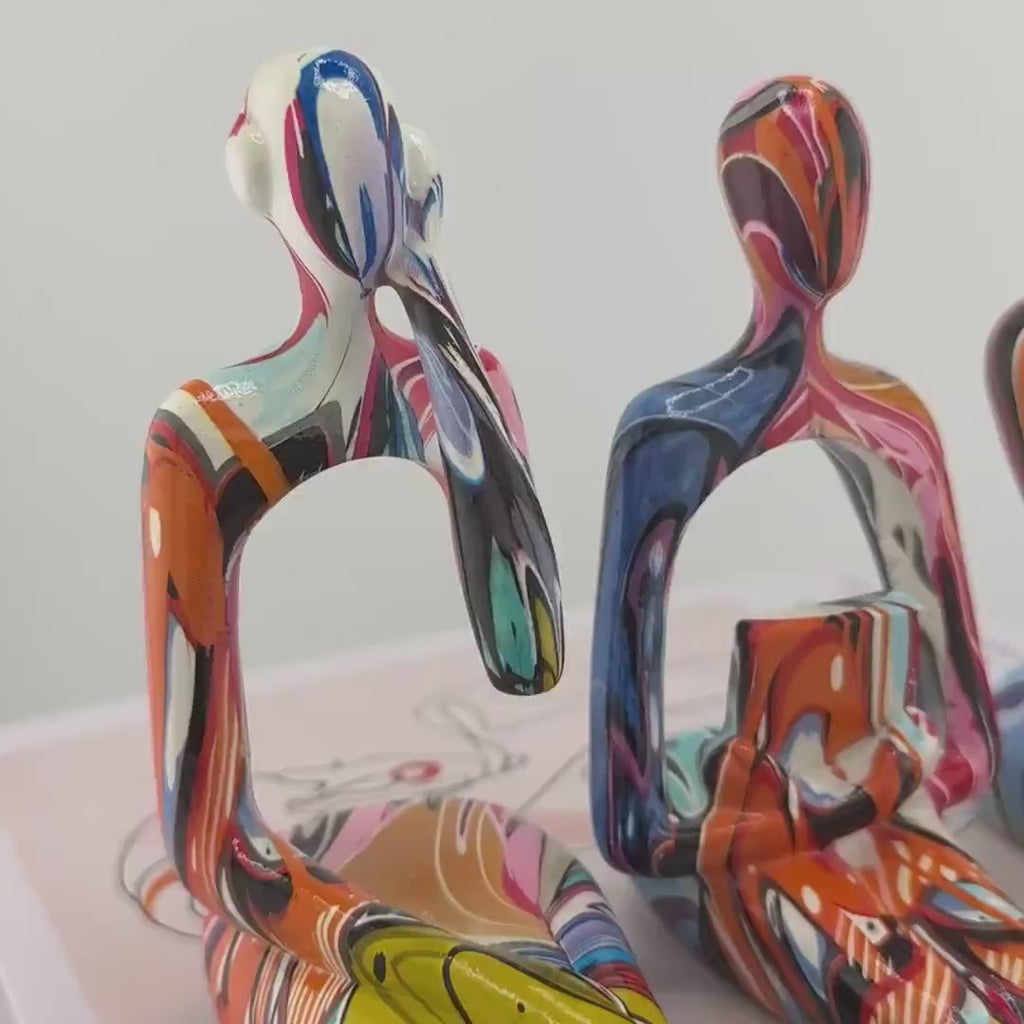 Minimalist colorful resin sculpture of three seated figures for modern home décor

