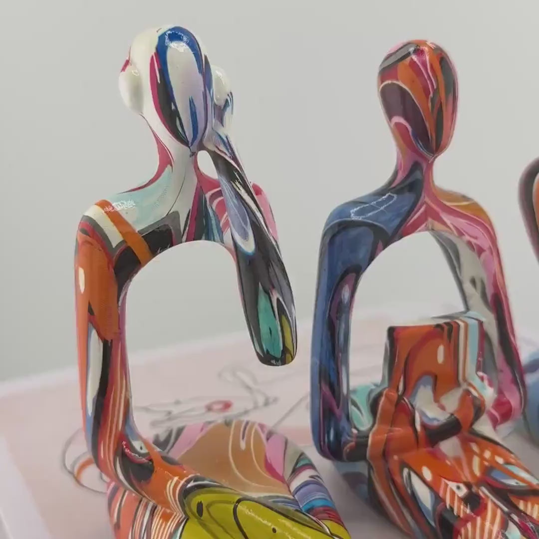 Minimalist colorful resin sculpture of three seated figures for modern home décor
